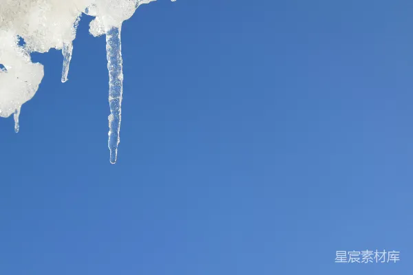 高清摄影 冰凌挂在雪地上，背景是明亮的蓝天。