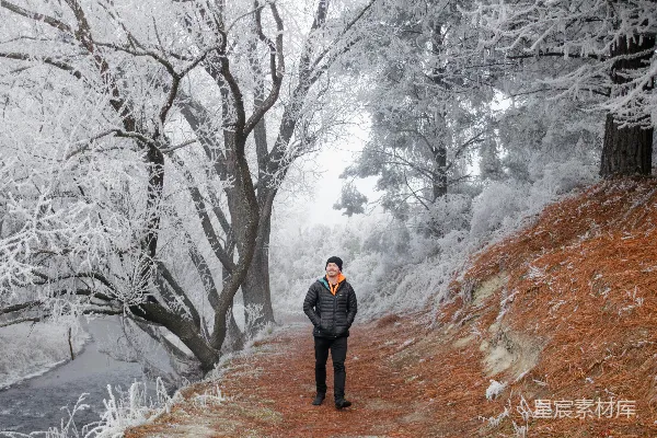 高清摄影 一个男人站在雪地里的小路上。