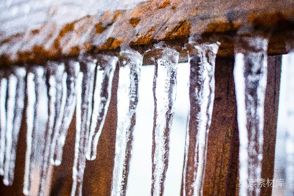 高清摄影 一个木制的长凳在雪天上覆盖着冰锥。