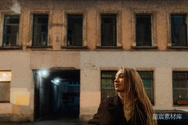 夜幕下女子倚靠在建筑物旁的姿势