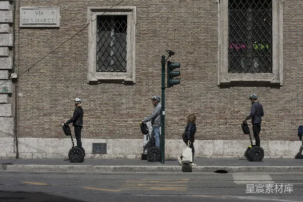 三人骑黑色脚踏滑板车