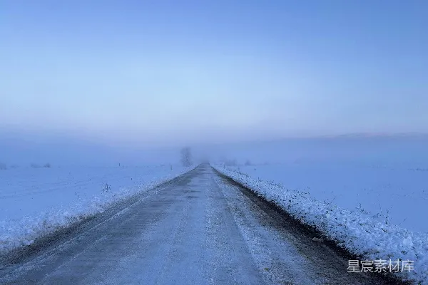 高清摄影 一条路在积雪覆盖的田野中间