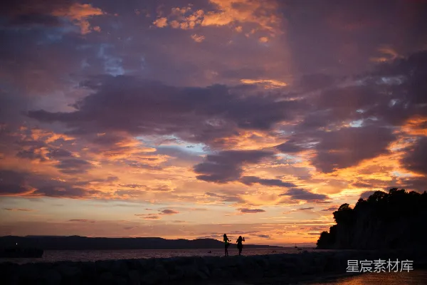 几人站在海滩上，天空中有乌云。