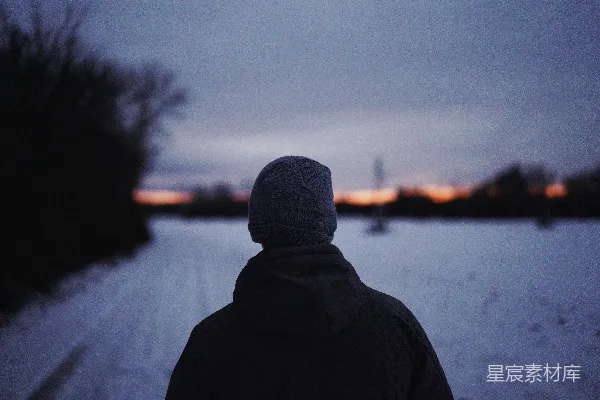 高清摄影 穿黑色连帽衫的人站在雪覆盖的田野旁边，白天。