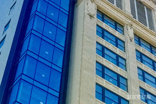 现代蓝玻璃建筑紧邻传统石质建筑。