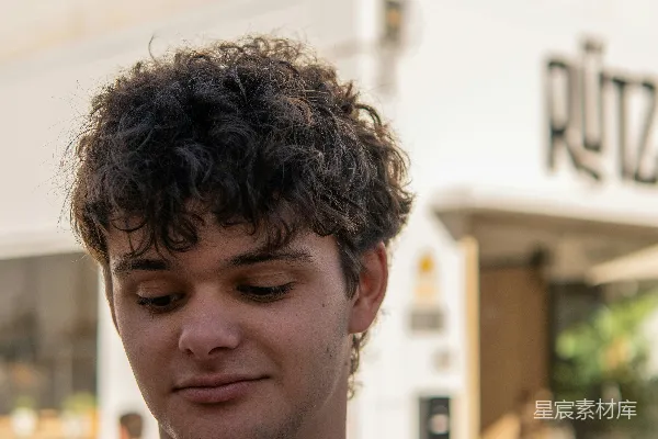 一个男人低头看着他的手机