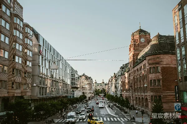 一条街道上车水马龙，旁边耸立着高大的建筑。