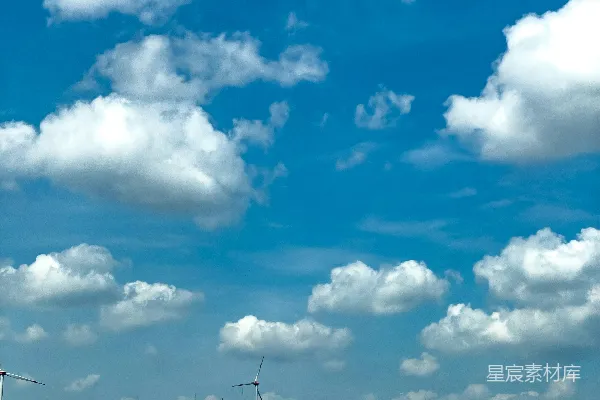 一辆车在背景中的风车旁边行驶。