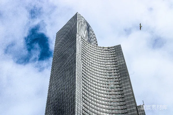 一座非常高大的建筑上有飞机在天空中飞行。