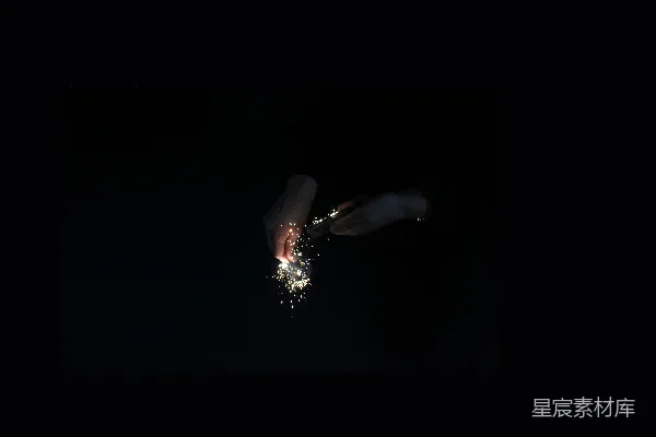 高清摄影 手在黑暗中用火石点燃金色火花。