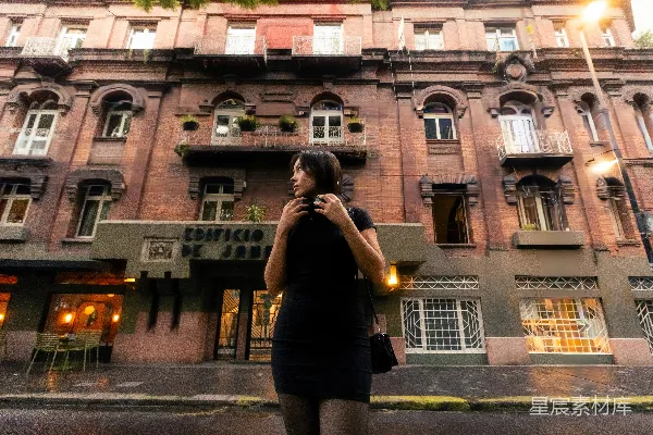 黑衣女子站在一座旧建筑前