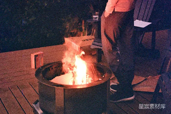 一个男人站在火旁边。