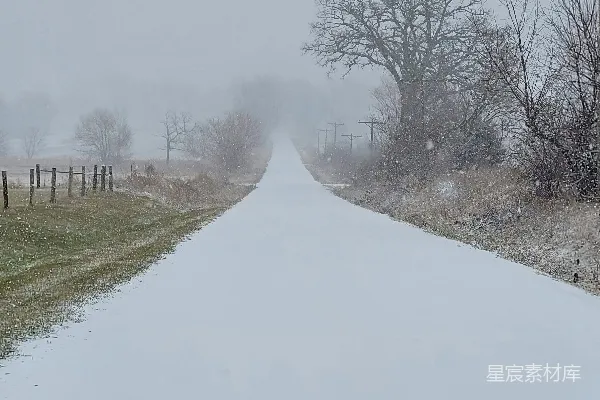远方有一根电话杆，覆盖着白雪的道路。