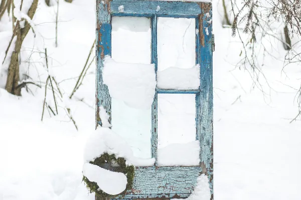 一间破旧的大门孤零零地坐落在一片覆盖着白雪的森林中央。