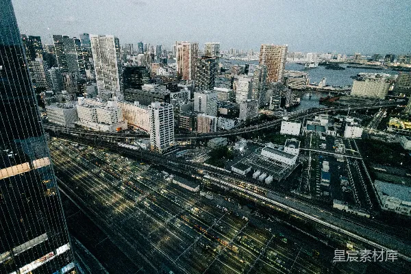 现代城市风光，黄昏时分有亮灯的铁轨。