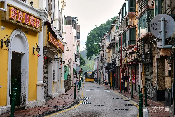 一条窄街，背景是有一座钟楼的黄色建筑。