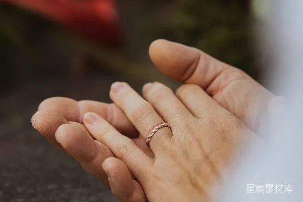 一个近镜头展示的人拿着婚戒