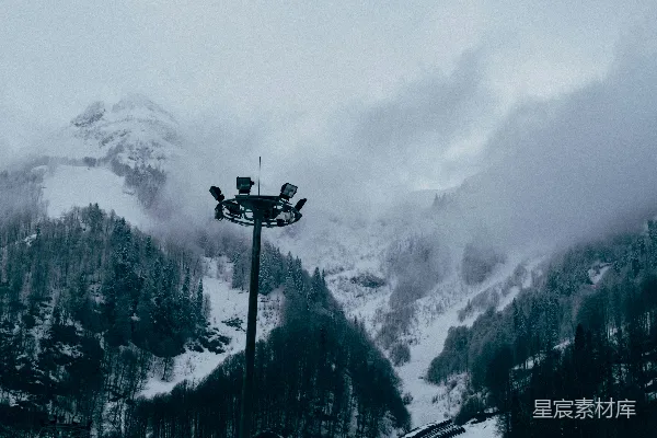 前方雪覆盖的山脚下有一盏路灯。