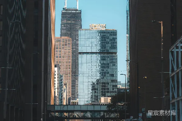 一个男人走在一旁有高大建筑物的街道上
