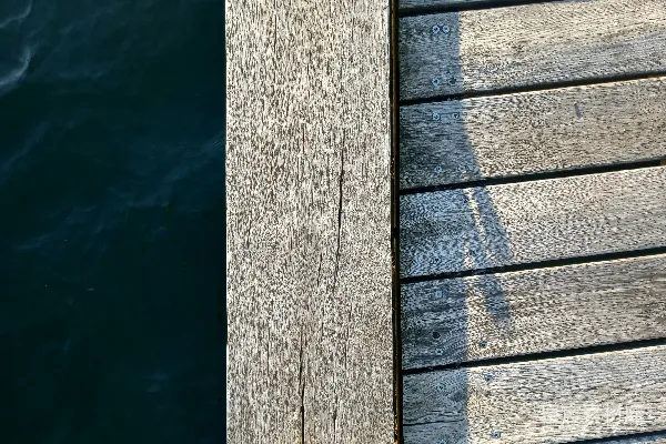 高清摄影 一个木制甲板，背景中有水体。