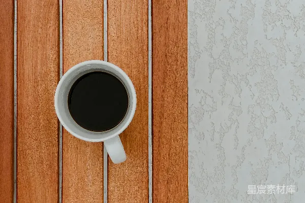 白色陶瓷小茶杯放在棕色木桌上