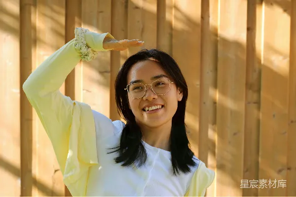 笑眯眯的女人用双手遮挡阳光。