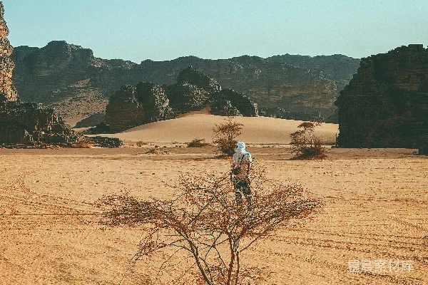 宇航员站在一片荒漠行星上。
