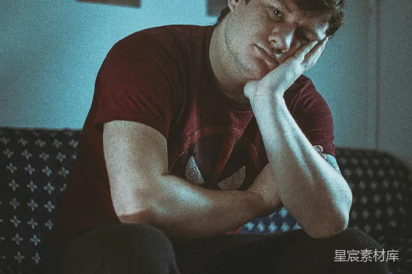 一个男人坐在沙发上用手捂着脸