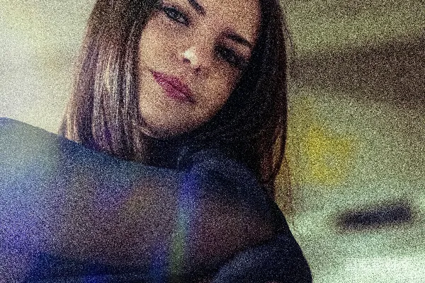 一位女性正在拿着手机摆姿势拍照。