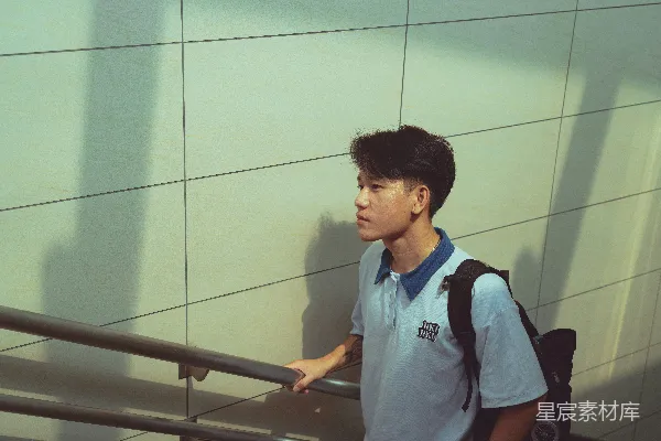 一个年轻人正在走上一段楼梯。