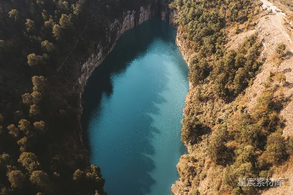 湖畔森林环绕的蔚蓝湖泊俯瞰图。