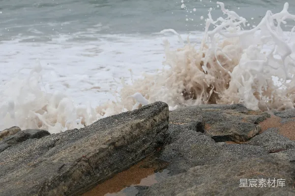 海边岩石上白天波浪拍打着海岸。