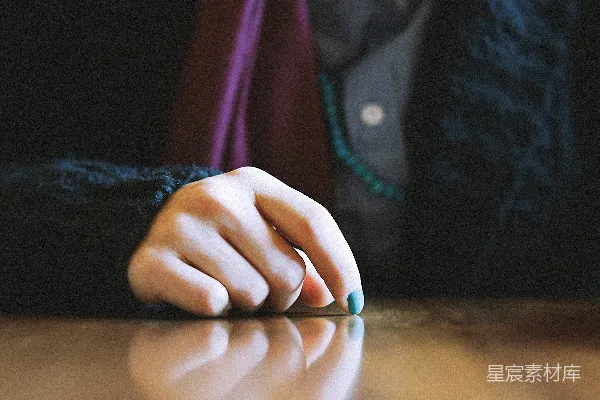 黑色长袖衫的人正拿着一张棕色的木桌