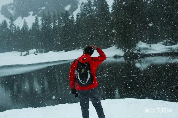 一个穿红色夹克的男人站在雪中