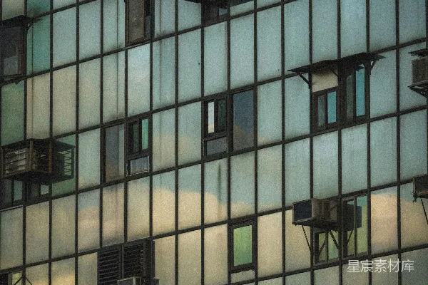 现代建筑立面有许多窗户和空调外机。