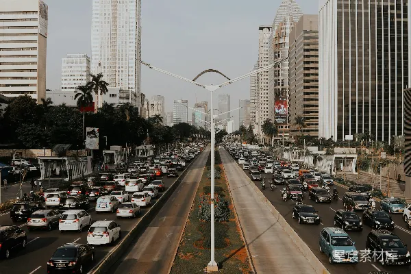 路上的汽车靠近高-rise建筑在白天