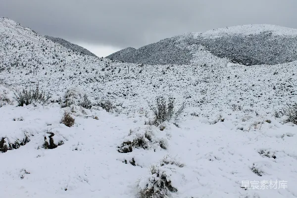 背景是山丘的雪覆盖着的田野