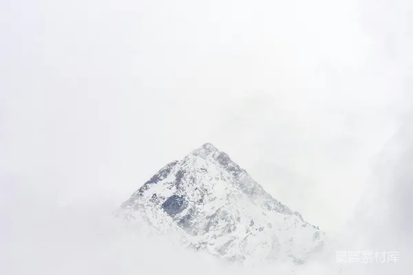 一座雪覆盖的山峰俯瞰着建筑物和城市道路。