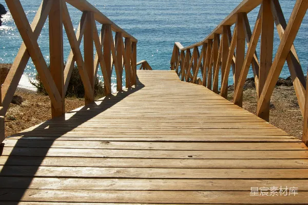 高清摄影 白天的海面上横跨着一座棕色木桥。