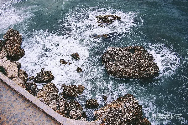 白天岩石地貌与海浪拍岸的景象