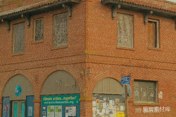 旧砖砌建筑物，有拱形门和 boarded 窗户。