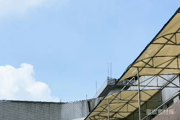 在蓝天白云下建造带有黄色遮阳篷的外立面。