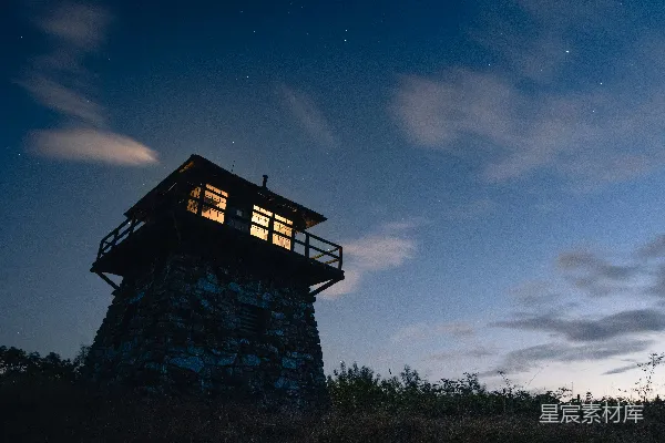一座小塔坐落在 hills 的顶部，在夜空下矗立。