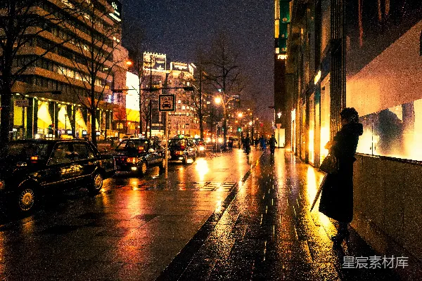 夜幕下人们走在人行道上