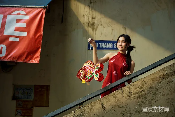 红衣女子手持彩色鱼灯