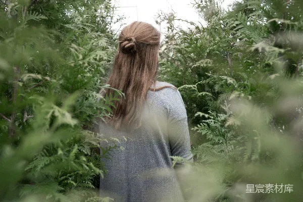 一个女人站在一丛植物的田野里