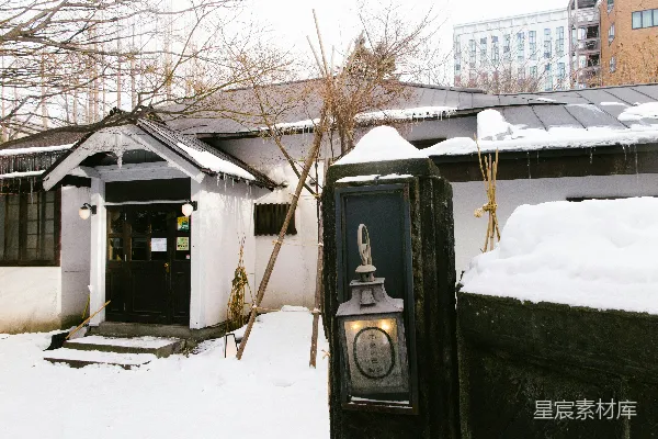 地上积雪的房子和门上的钟表