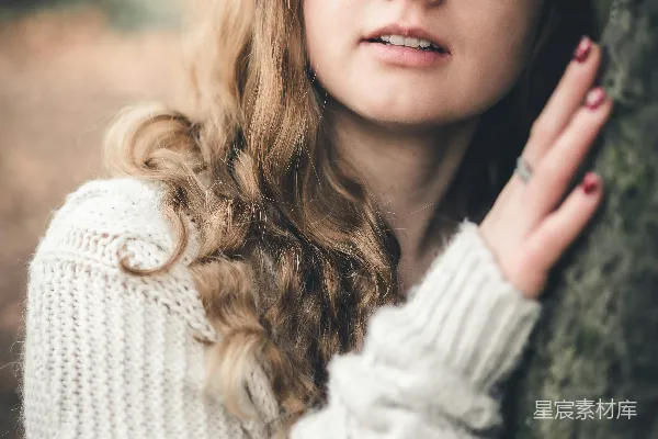 高清摄影 一个戴着眼镜的女人靠在一棵树上。
