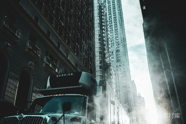 一辆大型卡车沿着附近高大建筑的街道行驶。
