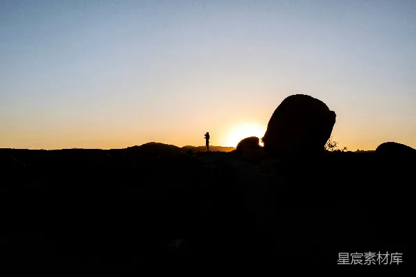 夕阳下站立在岩石上的身影
